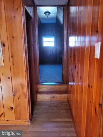 a view of a hallway with wooden floor and stairs