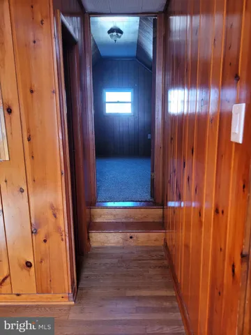 a view of a hallway with wooden floor and stairs