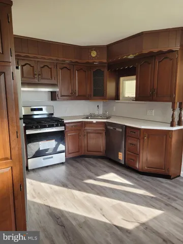 a kitchen with stainless steel appliances granite countertop a sink a stove and a refrigerator
