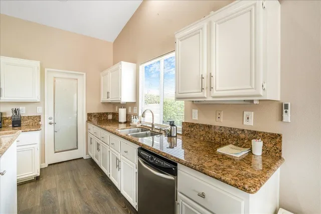 a kitchen with stainless steel appliances granite countertop a stove a sink and a refrigerator