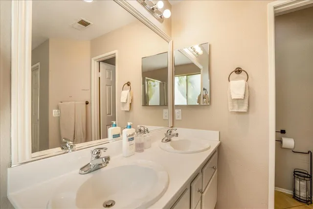 a bathroom with a granite countertop sink toilet and mirror