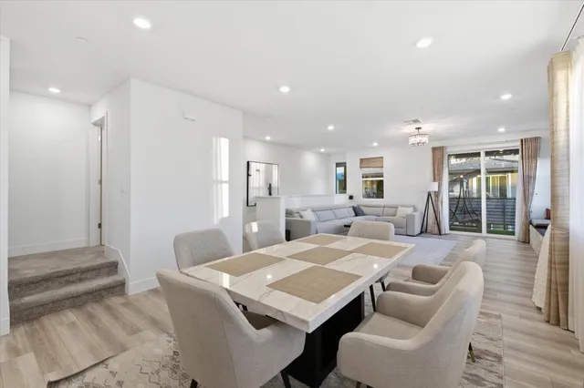 a living room with furniture a large window and wooden floor