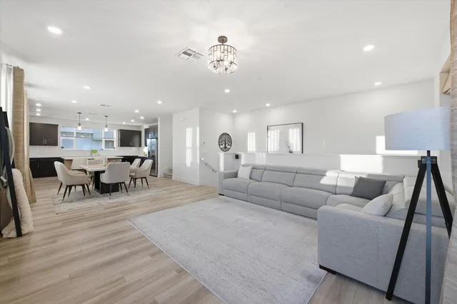 a living room with furniture and view of kitchen
