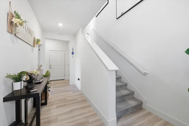 a view of a hallway with wooden floor and stairs