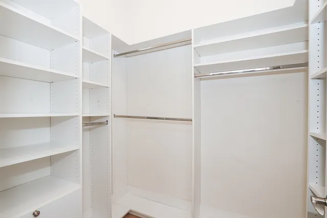 a view of walk in closet with empty racks