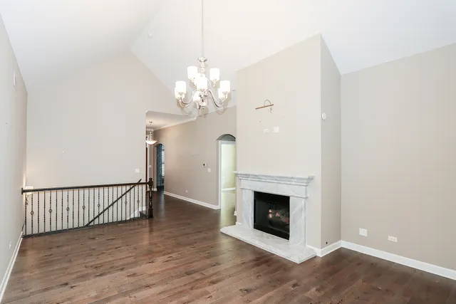 a view of a livingroom with a fireplace a chandelier and wooden floor