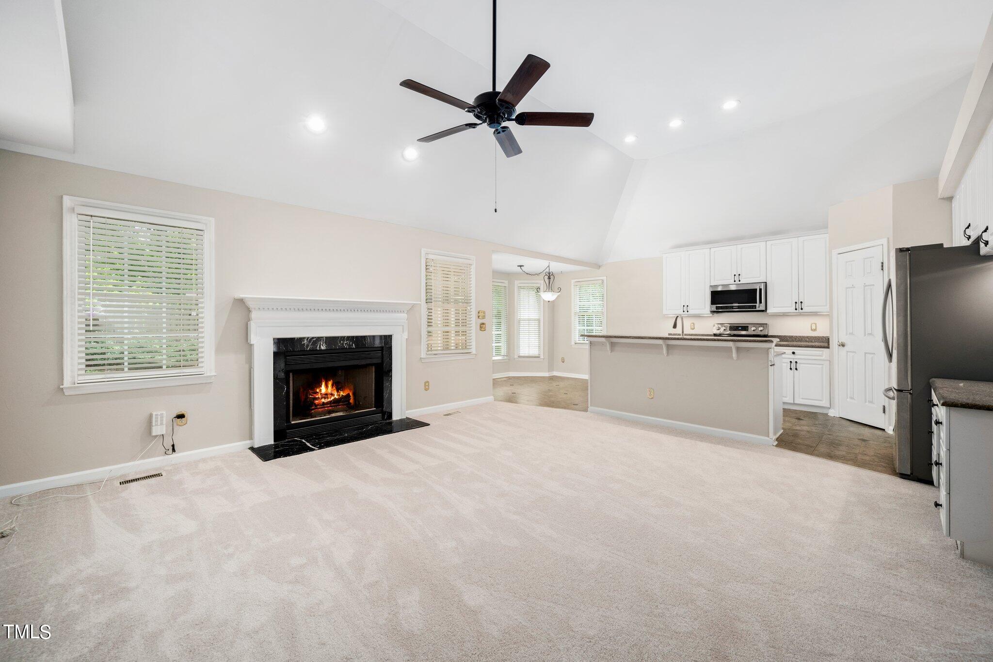 12216 Freemont Lane Raleigh, NC 27613 - Photo 11 of 23 a view of kitchen with furniture a refrigerator and a fireplace