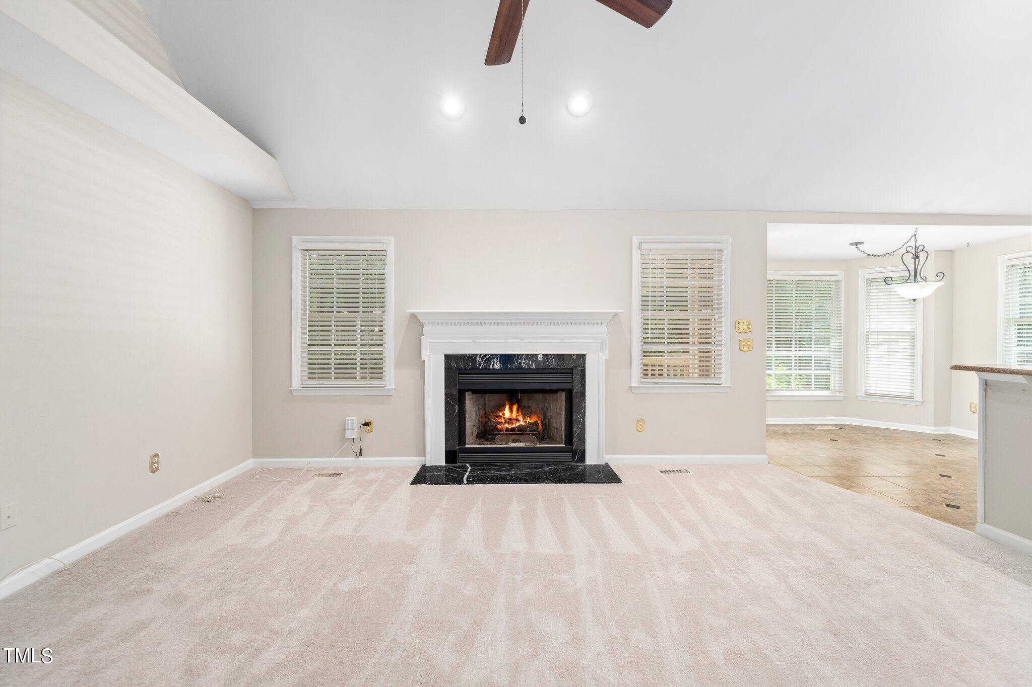 12216 Freemont Lane Raleigh, NC 27613 - Photo 12 of 23 an empty room with windows and fireplace