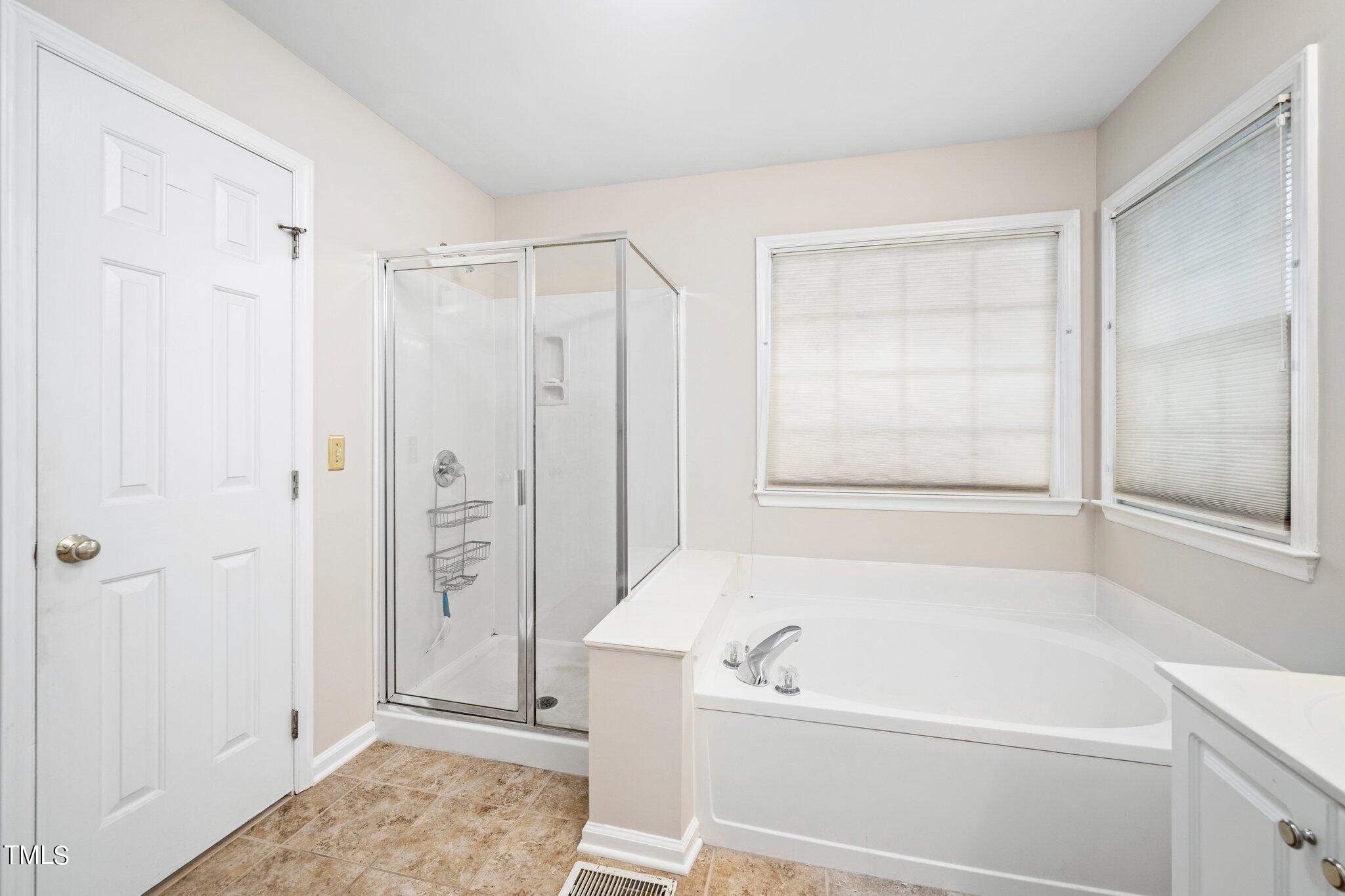 12216 Freemont Lane Raleigh, NC 27613 - Photo 17 of 23 a bathroom with a bathtub and a shower