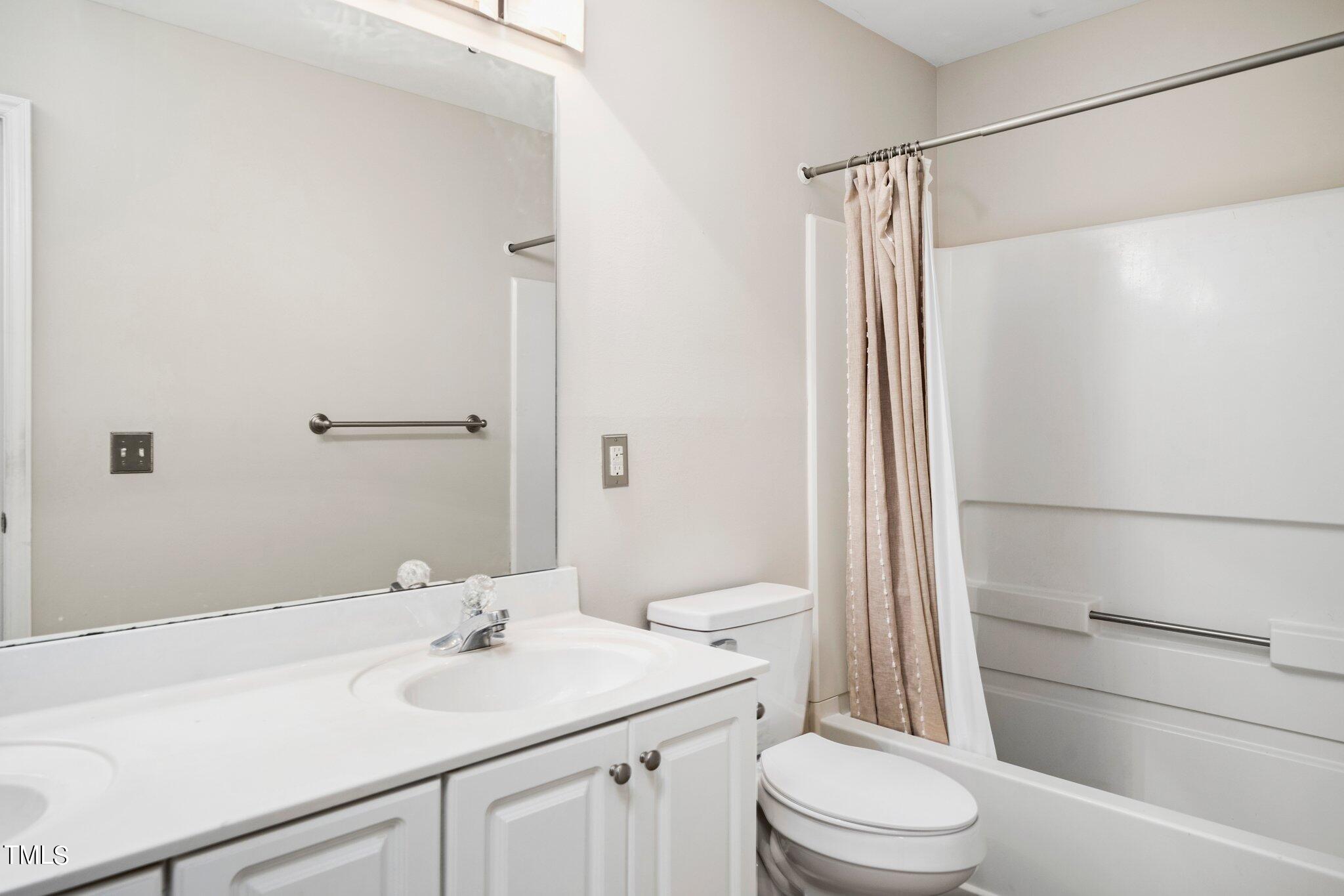 12216 Freemont Lane Raleigh, NC 27613 - Photo 20 of 23 a bathroom with a sink a toilet a mirror and shower