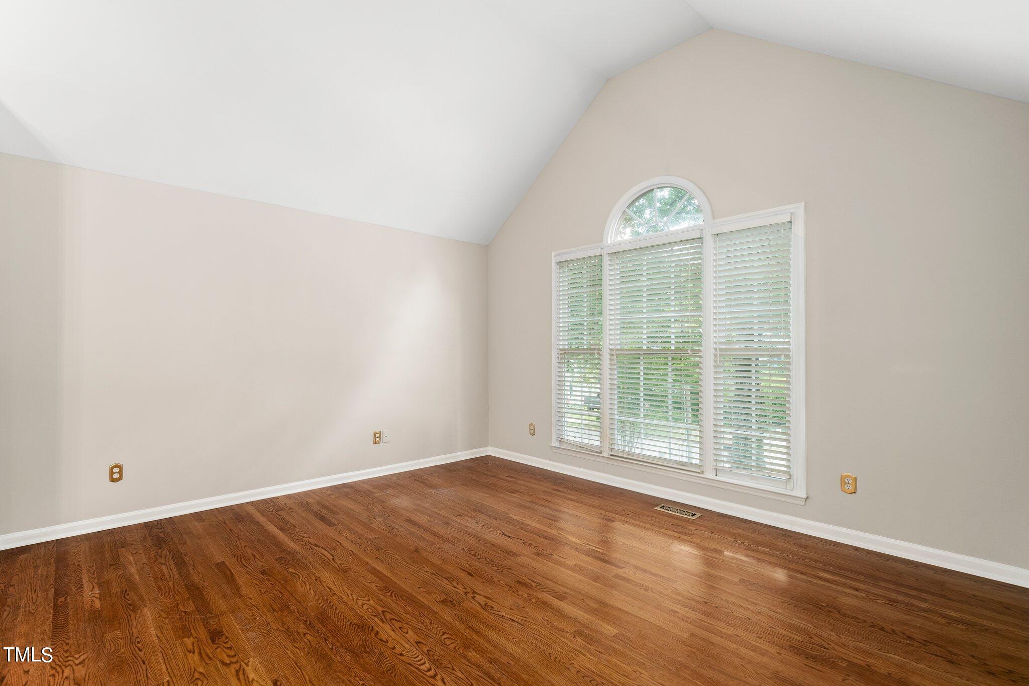 12216 Freemont Lane Raleigh, NC 27613 - Photo 4 of 23 an empty room with wooden floor and windows