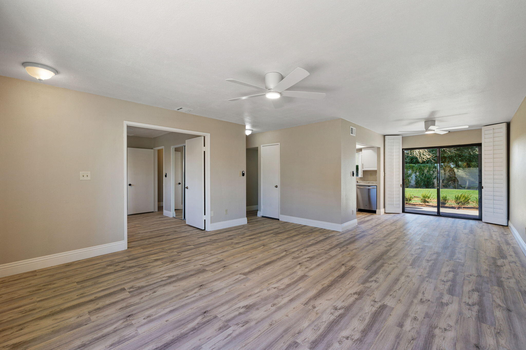 41045 Largo Palm Desert, CA 92211 - Photo 12 of 46 a view of an empty room with window wooden floor and a kitchen