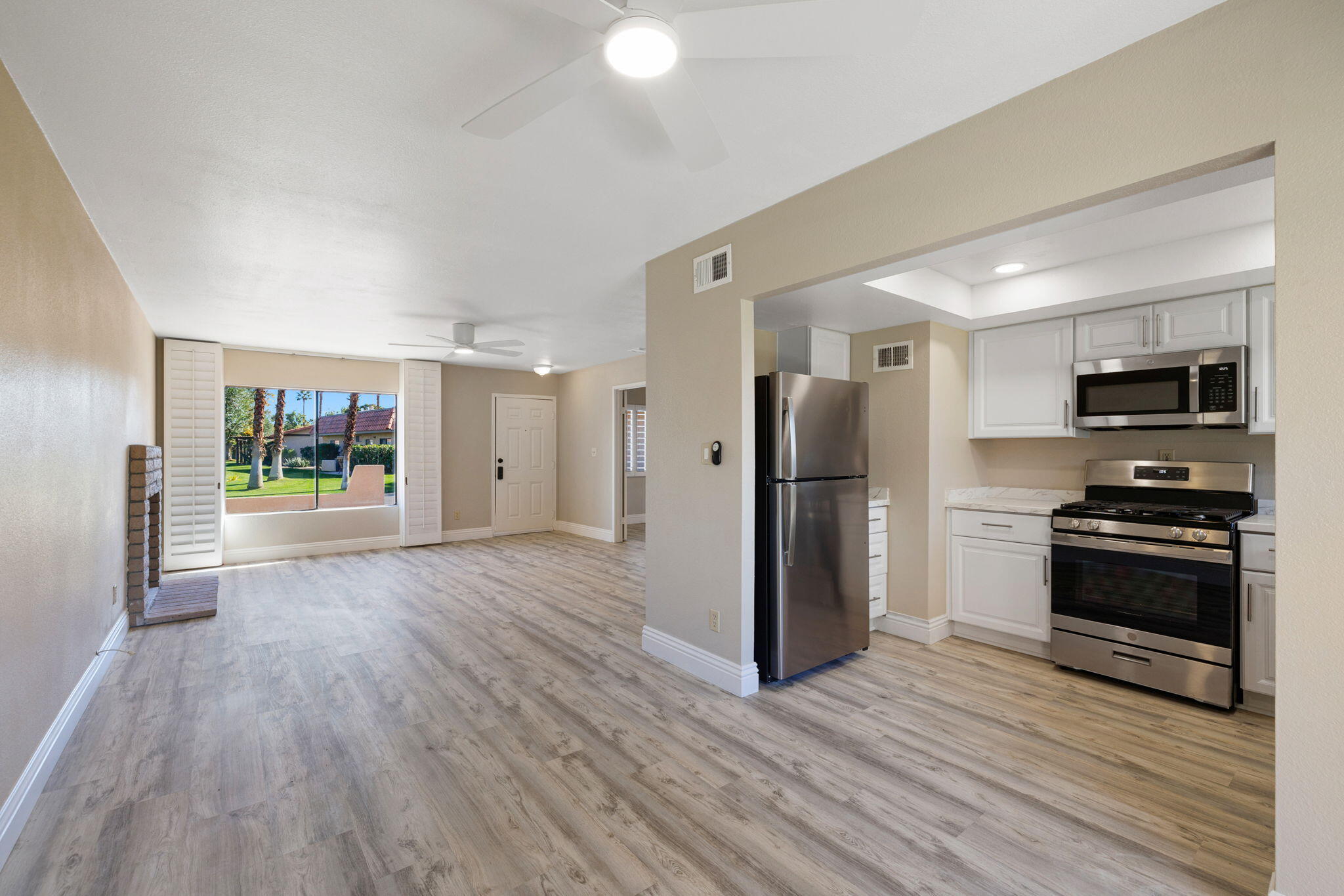 41045 Largo Palm Desert, CA 92211 - Photo 15 of 46 a view of a kitchen with refrigerator and wooden floor