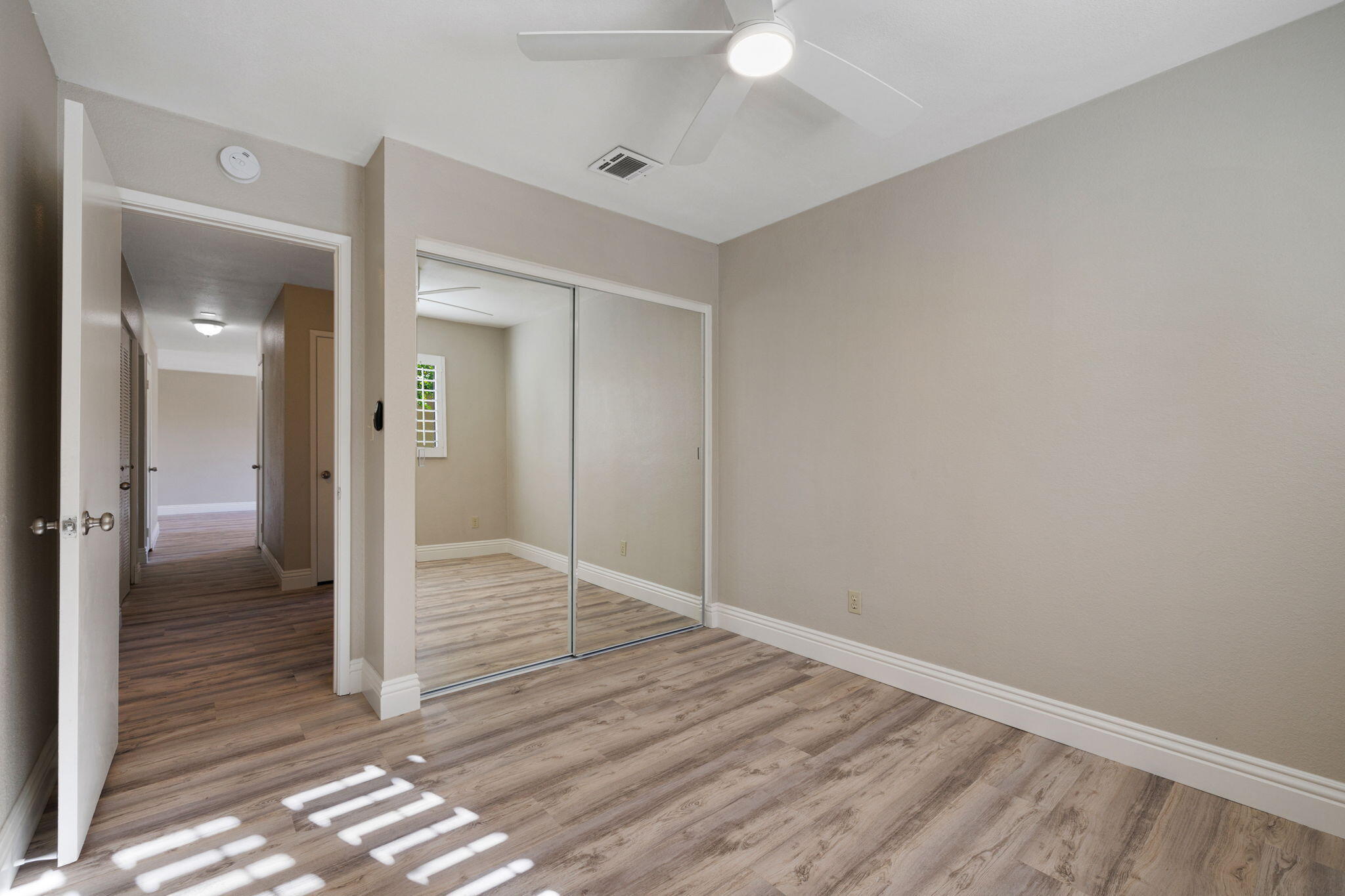 41045 Largo Palm Desert, CA 92211 - Photo 29 of 46 a view of a hallway with wooden floor and a bathroom