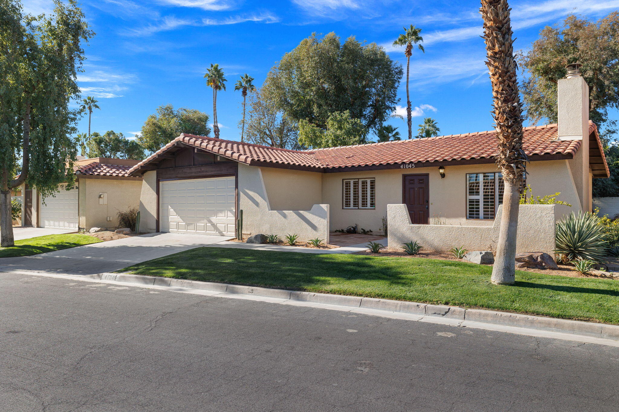 41045 Largo Palm Desert, CA 92211 - Photo 3 of 46 a front view of a house with garden