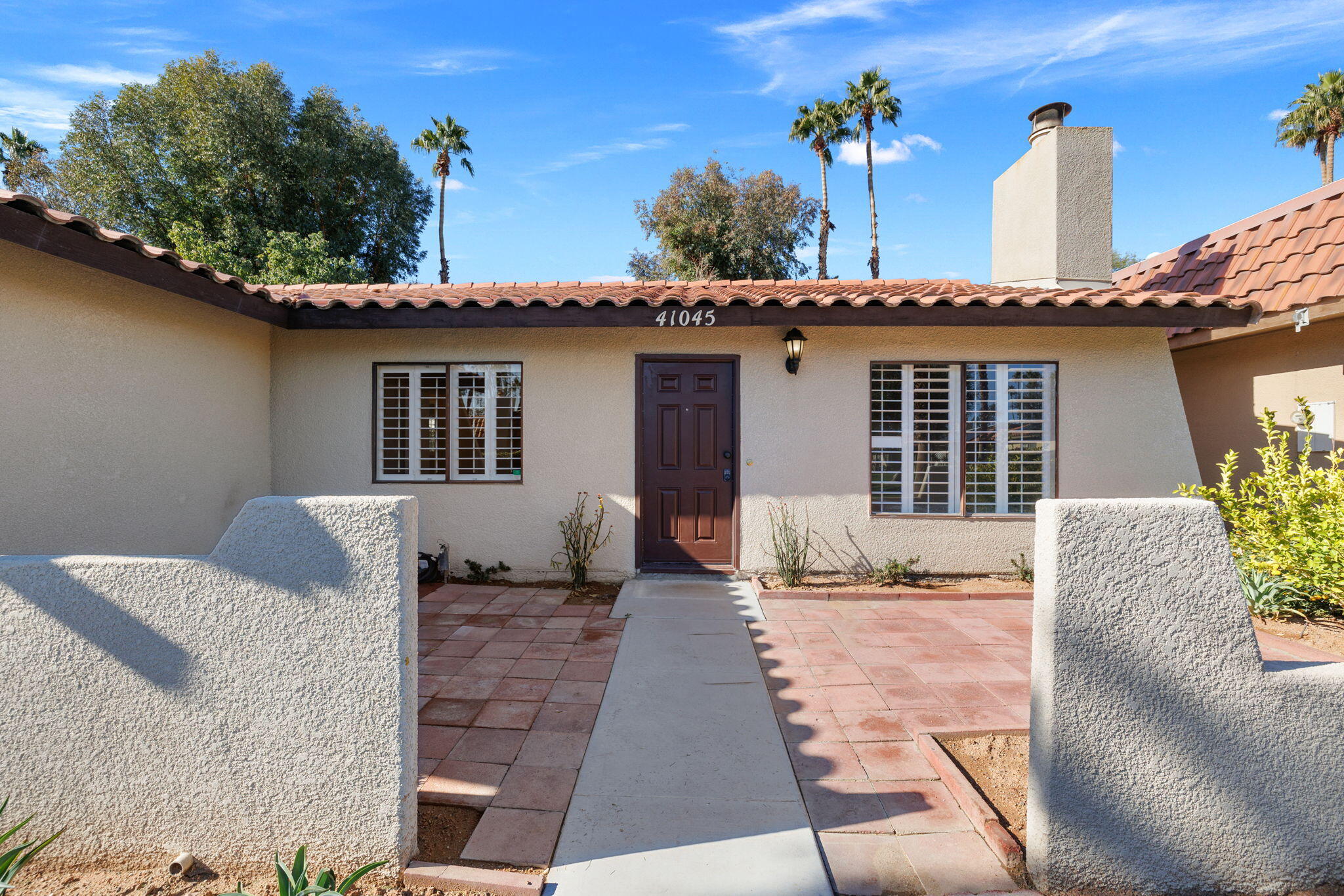 41045 Largo Palm Desert, CA 92211 - Photo 6 of 46 a front view of a house with a yard