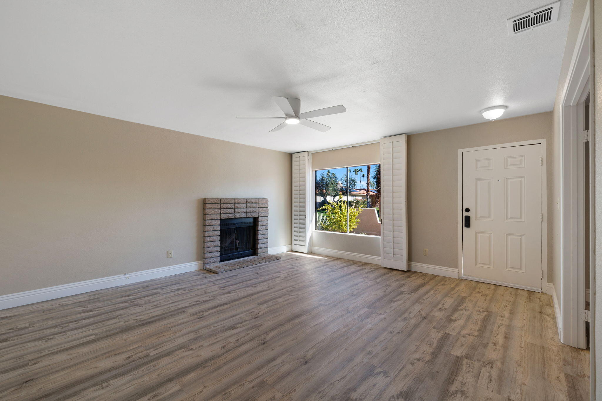 41045 Largo Palm Desert, CA 92211 - Photo 9 of 46 a view of an empty room with window and wooden floor