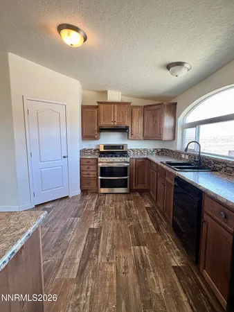 a kitchen with stainless steel appliances granite countertop a stove a sink and a microwave