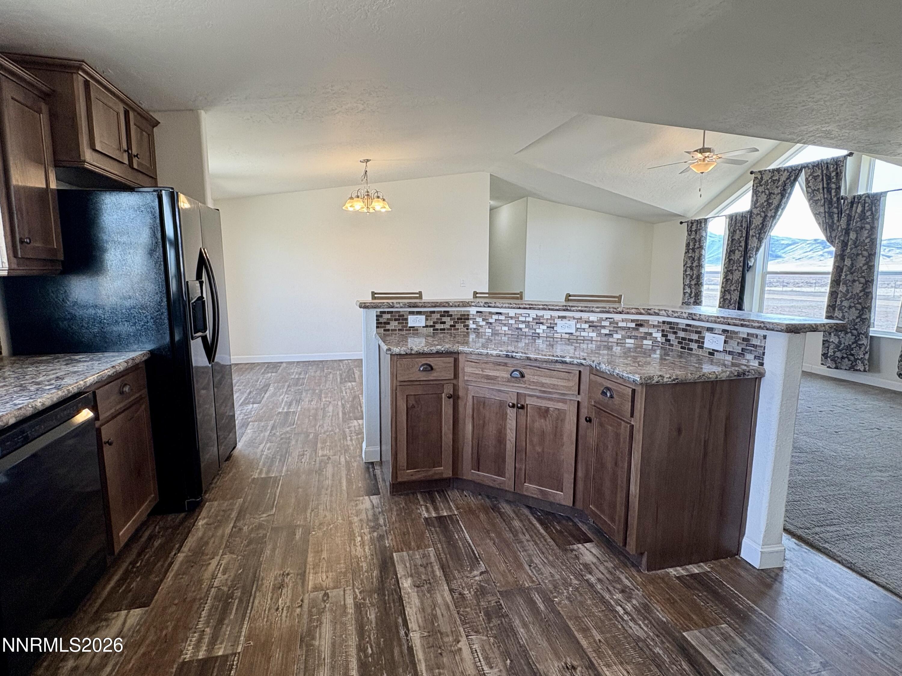 1415 Van Diest Road Winnemucca, NV 89445 - Photo 14 of 34 a kitchen with stainless steel appliances granite countertop a stove and a wooden floors
