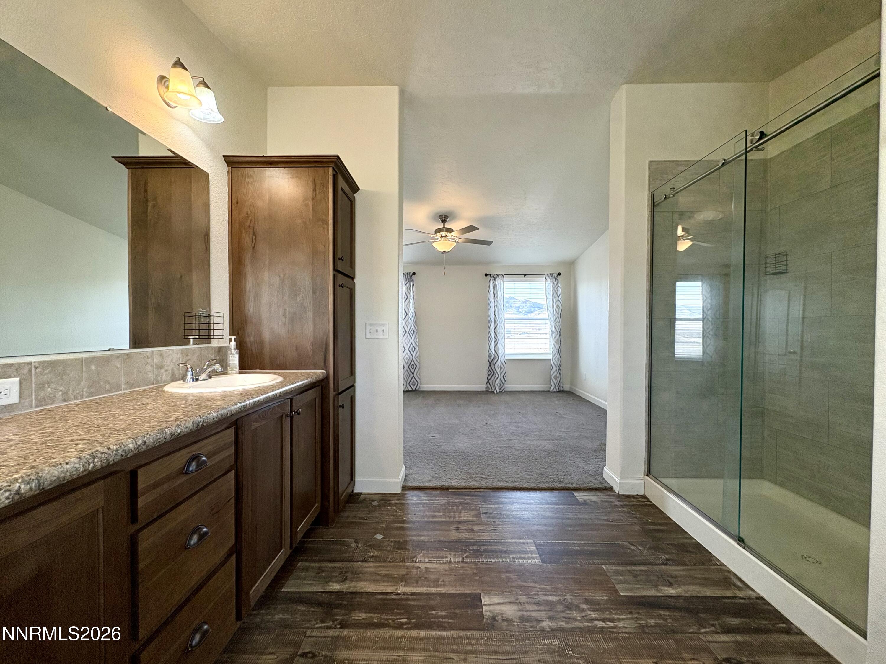 1415 Van Diest Road Winnemucca, NV 89445 - Photo 17 of 34 a bathroom with a granite countertop sink shower and a mirror