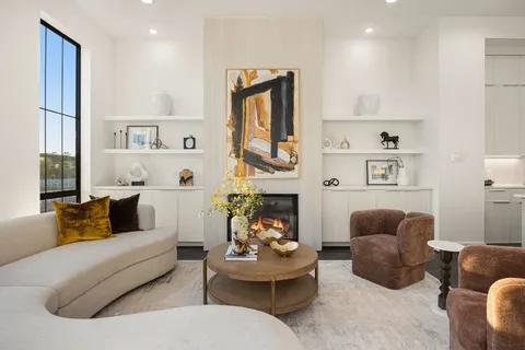 a living room with furniture fireplace and a large window