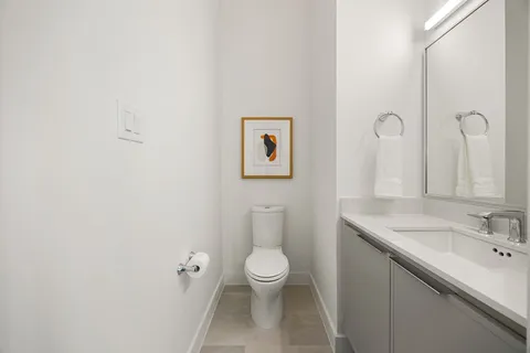 a bathroom with a toilet a sink and mirror