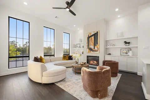 a living room with fireplace furniture and a large window
