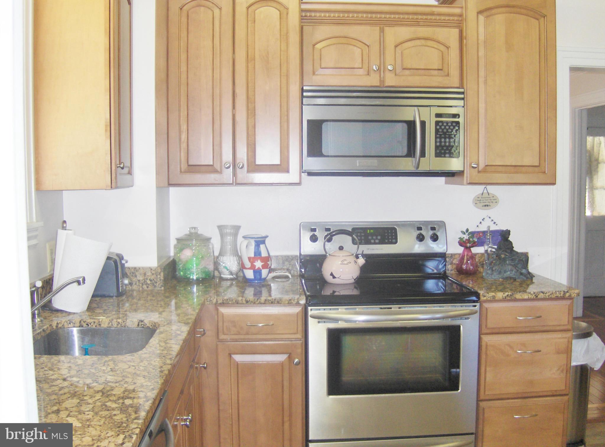 4957 Muddy Creek Road West River, MD 20778 - Photo 8 of 29 a kitchen with granite countertop a sink stove and cabinets