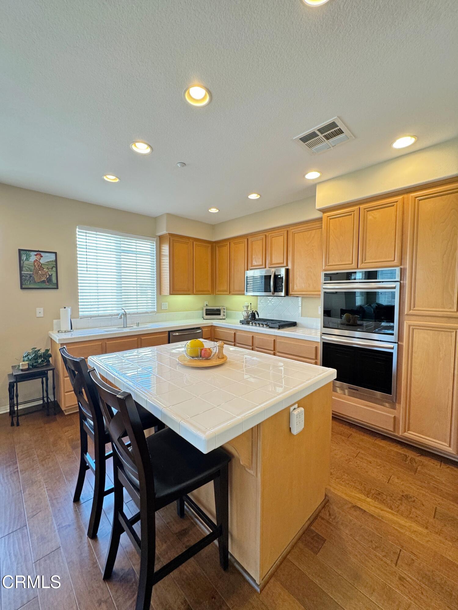 1240 Bayside Lane Oxnard, CA 93035 - Photo 26 of 69 a large kitchen with a table and chairs
