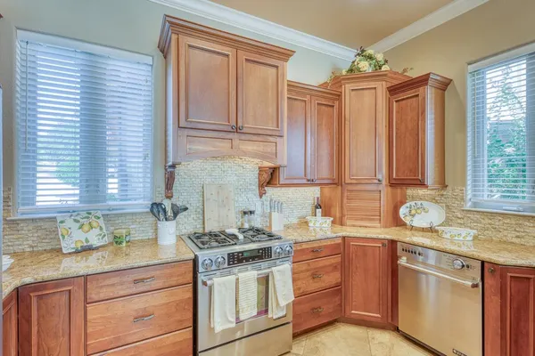 a kitchen with stainless steel appliances granite countertop a sink a stove and cabinets