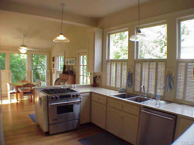 405 Polk Street Raleigh, NC 27604 - Photo 7 of 10 a kitchen with stainless steel appliances kitchen island a stove a sink and a large window