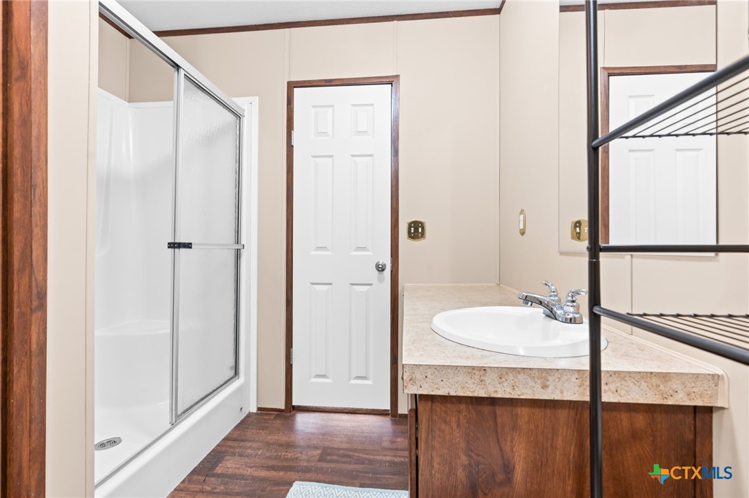 996 County Road 421 Evant, TX 76525 - Photo 15 of 48 a bathroom with a granite countertop sink and a mirror