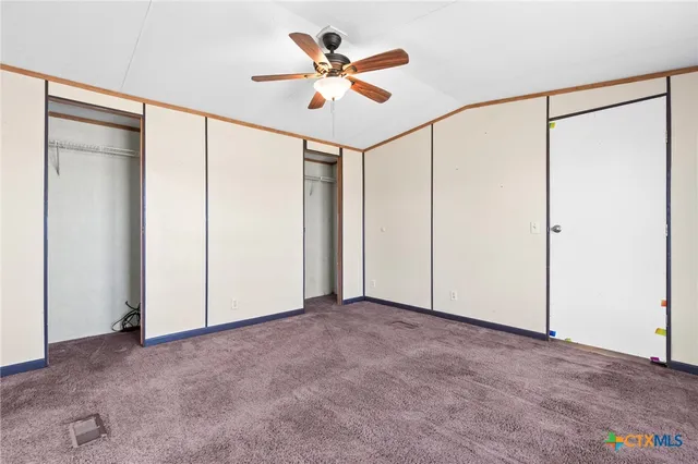 a view of backyard with large tree and wooden fence