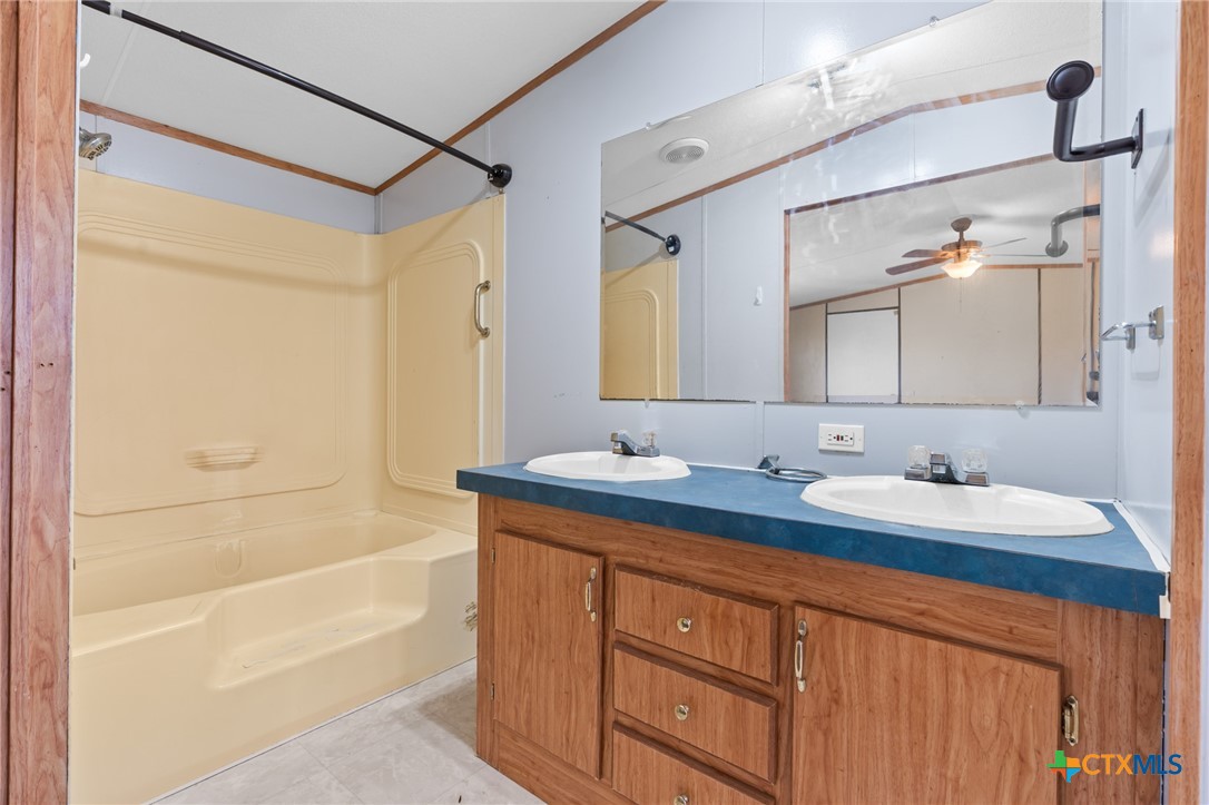 996 County Road 421 Evant, TX 76525 - Photo 27 of 48 a bathroom with a tub sink and mirror