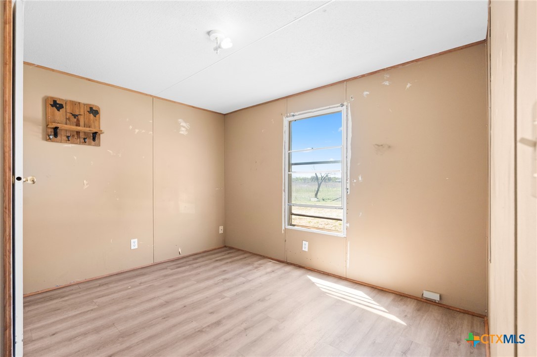996 County Road 421 Evant, TX 76525 - Photo 29 of 48 a view of an empty room with wooden floor and a window