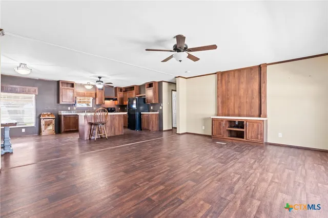 a kitchen with stainless steel appliances granite countertop a sink a stove a refrigerator a microwave oven with wooden floor and cabinets