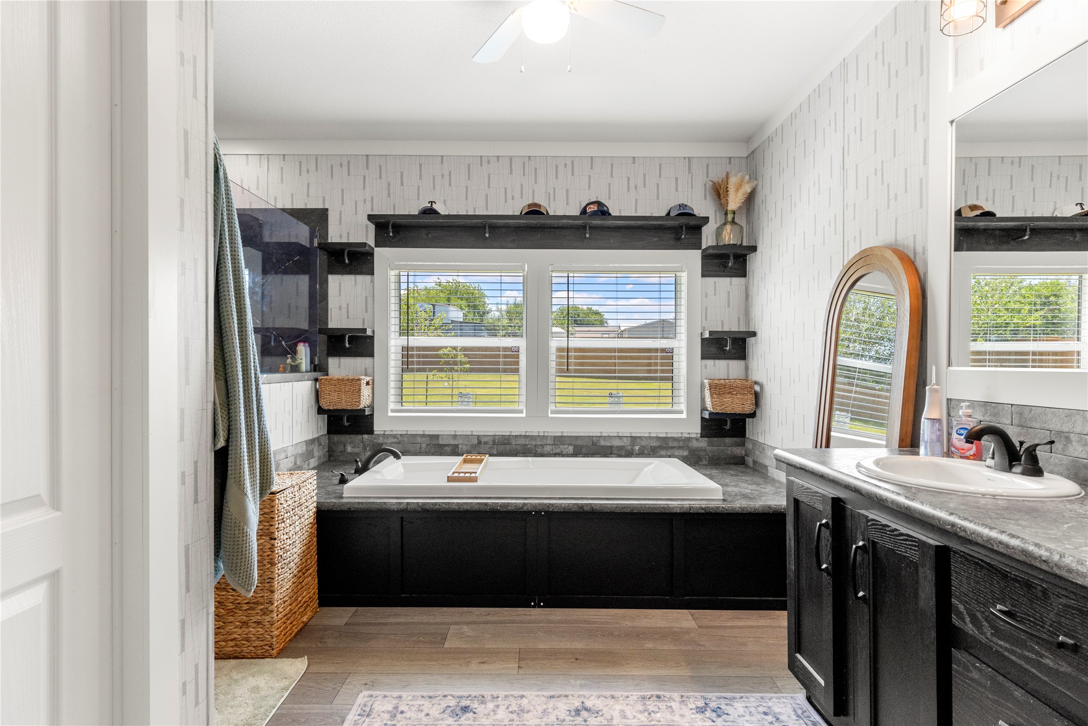 201 Greenfield Road Kyle, TX 78640 - Photo 12 of 28 Relax in the deep soaking tub, beneath sun-filled windows, in this primary bathroom oasis.