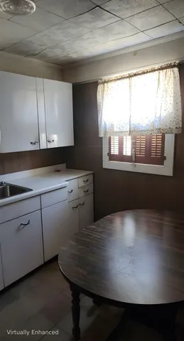 a kitchen with kitchen island a sink cabinets and window