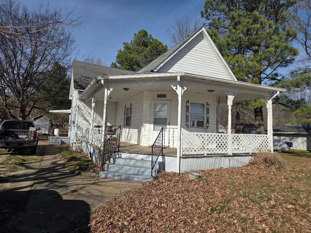 a view of a house with a large tree in front of it