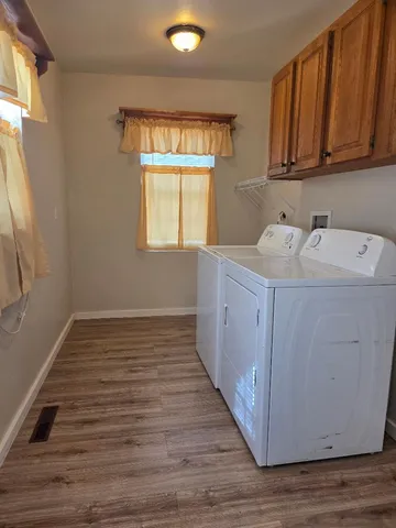 a kitchen with a wooden floor washer and dryer