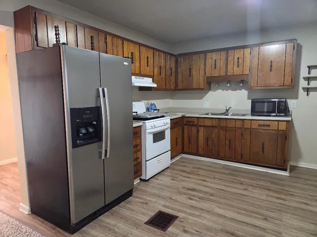 a kitchen with stainless steel appliances granite countertop a refrigerator stove and sink