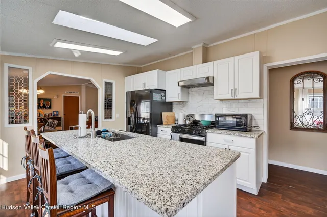 a kitchen with stainless steel appliances granite countertop a stove refrigerator and wooden cabinets