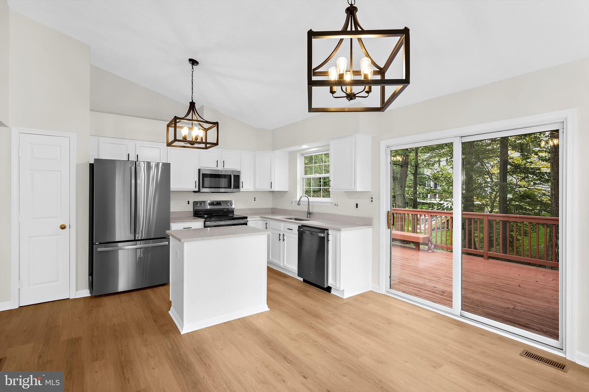 2335 Golden Chapel Road Odenton, MD 21113 - Photo 12 of 37 a kitchen with stainless steel appliances granite countertop a refrigerator a stove a microwave and a view of dining livingroom