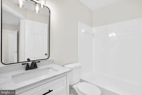 a bathroom with a sink a toilet and mirror