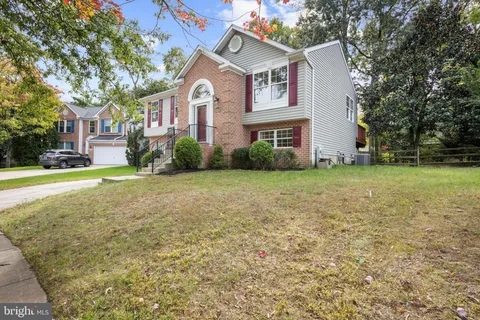 a view of a big house with a big yard and large trees