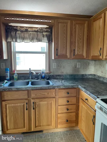 a kitchen with granite countertop a sink cabinets and window