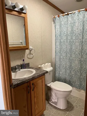 a bathroom with a granite countertop sink mirror vanity and toilet
