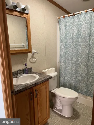a bathroom with a granite countertop sink toilet and a mirror