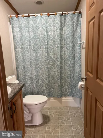 a bathroom with a toilet and a shower curtain