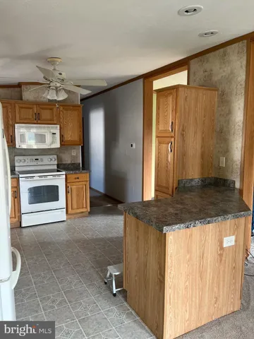 a kitchen with kitchen island granite countertop a stove a sink and a refrigerator